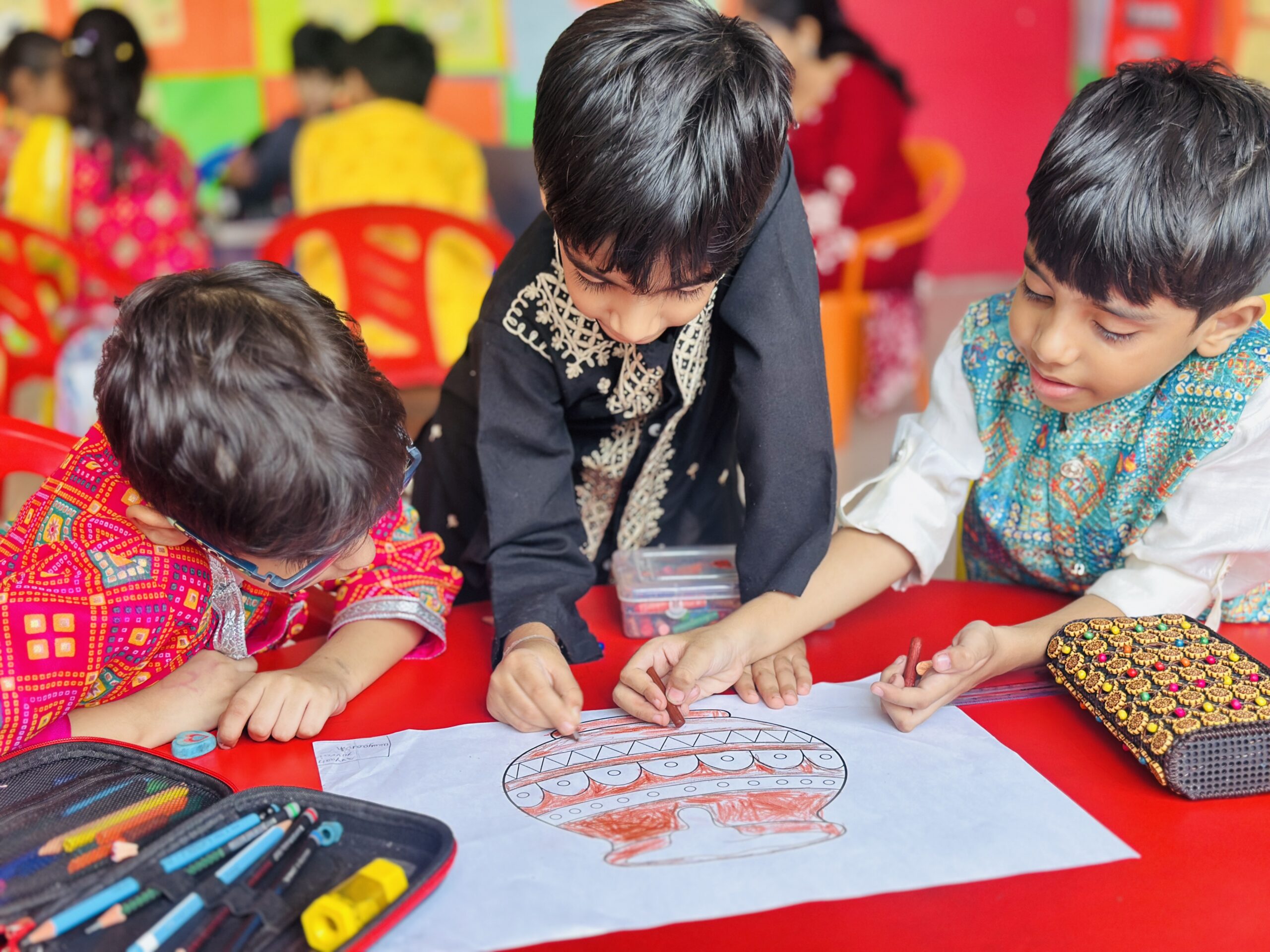 Primary students colouring a matki for Janmashtami at Modern School Lucknow