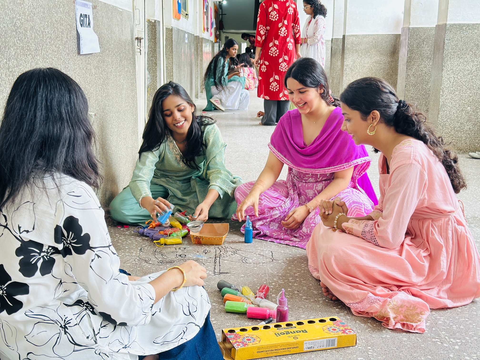 Senior students working together on a rangoli for the Inter-House Rangoli Competition